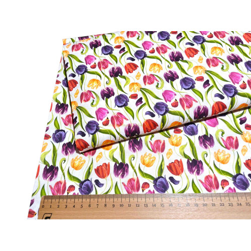 Detail kvetinového vzoru na bavlnenom plátne – sýte fialové, ružové, červené a žlté tulipány so zelenými listami. Vzdušná 100% bavlna z e-shopu Kreativcentrum Margo.