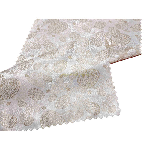 Detail luxusnej obojstrannej žakárovej štóly vo vanilkovej farbe s vytkávanými veľkonočnými kraslicami a zlatým lurexom. Teflónová úprava proti fľakom, moderný ozdobne zatavený okraj do cik-caku.